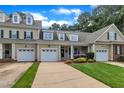 A beige townhome features an attached garage, a front lawn, and a driveway at 1326 Fairview Club Dr, Wake Forest, NC 27587
