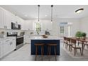 Elegant kitchen features marble countertops, stainless appliances, a navy island, and a cozy dining area at 1805 Abby Knoll Dr, Apex, NC 27502