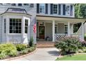 Inviting porch of a home featuring classic columns, meticulous landscaping, and brick entryway at 1830 Wilshire Ave, Raleigh, NC 27608