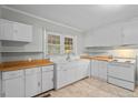 The kitchen features white cabinetry, butcher block countertops, and tile flooring at 203 Spring Street St, Louisburg, NC 27549
