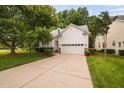 Attractive home with a lush green lawn, mature trees, and a spacious two-car garage at 208 Rockport Ridge Way, Cary, NC 27519