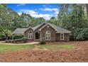 Traditional brick home featuring arched windows, lush landscaping, and a well-manicured front yard at 2095 Woodberry Dr, Clayton, NC 27527
