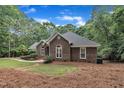 Brick residence showcasing arched windows, manicured greenery, and a well-maintained lawn at 2095 Woodberry Dr, Clayton, NC 27527