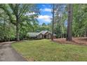 Brick home nestled among mature trees, boasting arched windows and a beautifully landscaped lawn at 2095 Woodberry Dr, Clayton, NC 27527
