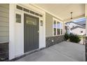 Inviting covered front porch with stone accents and a contemporary front door at 2223 Copper Pond Way, Fuquay Varina, NC 27526
