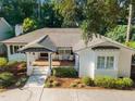 Aerial view of a well maintained home with manicured yard and a brick front porch in a lush, green neighborhood at 227 W Drewry Ln, Raleigh, NC 27609