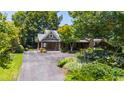 Landscaped front yard and driveway leading to a stone home with an attached portico at 2707 Anderson Drive Dr, Raleigh, NC 27608
