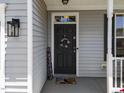 Up-close view of front door with patriotic decor and a charming covered porch at 300 Stobhill Ln, Holly Springs, NC 27540