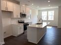 Bright kitchen with white cabinets, stainless steel appliances, and large island at 3113 White Blossom Ct, Raleigh, NC 27610