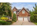 Attractive brick house featuring a two-car garage, well-maintained lawn, and colorful mature landscaping at 315 Birdwood Ct, Cary, NC 27519