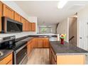 Well-lit kitchen featuring stainless steel appliances, granite countertops and laminate floors at 3825 Cary Glen Blvd, Cary, NC 27519