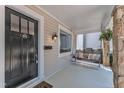 Welcoming front porch with a hanging swing, stone columns, and a stylish front door at 406 E Whitaker Mill Rd, Raleigh, NC 27608