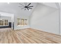 Spacious living room with wood-look flooring, a ceiling fan, and abundant natural light from a large window at 5027 Preacher Holmes Rd, Graham, NC 27253