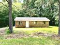 Charming single-story brick home surrounded by lush greenery, presenting a peaceful, secluded feel at 525 Locust Rd, Hillsborough, NC 27278