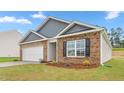 Cozy home with brick and siding, showcasing a well-maintained lawn and an attached garage at 528 Lochalsh Dr, Gibsonville, NC 27249