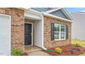 Welcoming front entrance showcasing brickwork, white siding, and a black front door and window shutters at 528 Lochalsh Dr, Gibsonville, NC 27249