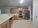 Well-lit kitchen featuring stainless steel appliances, ample countertop space, and wood cabinetry at 6408 Bunker Hill Dr, Raleigh, NC 27610