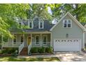 Inviting home with a covered front porch, a yellow front door, and well-maintained landscaping at 716 Beddingfield Dr, Knightdale, NC 27545