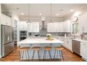 Spacious kitchen features a large center island with seating, quartz countertops, and stainless appliances at 1020 Regency Cottage Pl, Cary, NC 27518