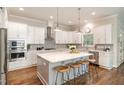 Beautiful kitchen with white cabinets, stainless steel appliances, quartz countertops, and a center island at 1020 Regency Cottage Pl, Cary, NC 27518