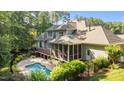 Beautiful backyard featuring a pool, screened in porch, mature trees, and plenty of space for outdoor entertaining at 1028 Harpers Ridge Ct, Wake Forest, NC 27587