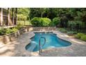 Custom pool is surrounded by stone, offering a secluded space for relaxation at 1028 Harpers Ridge Ct, Wake Forest, NC 27587