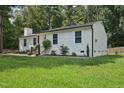 Well-manicured lawn surrounds this home with freshly painted white exterior and trimmed windows at 1104 Suterland Rd, Cary, NC 27511