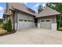 Attached three-car garage offering ample parking space with a concrete driveway and stone accent walls at 1212 Gunnison Pl, Raleigh, NC 27609