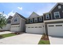 New townhomes featuring attached garages, manicured lawn, and traditional curb appeal at 1218 Tredenham Way, Durham, NC 27703