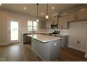 Bright, modern kitchen features an island, stainless appliances, and recessed lighting at 1218 Tredenham Way, Durham, NC 27703