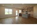 Open concept living area showcasing hardwood floors and an adjacent eat-in kitchen at 1218 Tredenham Way, Durham, NC 27703
