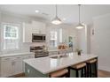 Bright and modern kitchen featuring a large island, white cabinets, and stainless steel appliances at 1304 Castlebay Rd, Durham, NC 27703