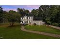 Charming two-story home with a manicured lawn, mature trees, and inviting front entrance at 1524 Wedgewood Dr, Graham, NC 27253
