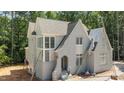 New construction home featuring a light gray brick exterior, arched entryway, and grand windows at 1529 Lake Adventure Ct, Raleigh, NC 27613