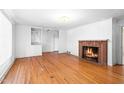 Spacious living room featuring hardwood floors, a brick fireplace, and built in shelves at 1702 Pinecrest St, Burlington, NC 27215