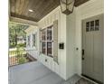 Charming front porch with wood ceiling features stylish lighting and classic architectural details at 201 S Ennis St, Fuquay Varina, NC 27526