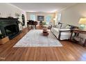 Cozy living room featuring fireplace, hardwood floors, piano, and natural light at 207 Wood Cir, Chapel Hill, NC 27514