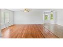 Sunlit living room with hardwood floors and large windows at 209 E Church St, Creedmoor, NC 27522