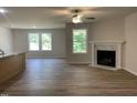 Bright living room featuring hardwood floors, a ceiling fan, and a fireplace with marble surround at 265 Eason Creek Way, Clayton, NC 27527