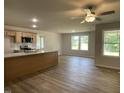 Open-concept living room featuring natural light, wood flooring and a ceiling fan at 265 Eason Creek Way, Clayton, NC 27527