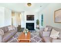 Bright living room features a fireplace, hardwood floors, and comfortable sofas at 27 Stonewall Way, Durham, NC 27704