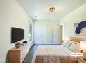 Serene main bedroom with plush rug, TV, a bright window and ample closet space at 27 Stonewall Way, Durham, NC 27704