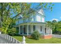Charming two-story home boasts a wrap-around porch with stately columns and a metal roof at 29 Oak St, Roxboro, NC 27573