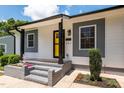Charming home featuring a bright yellow door, gray accents, and professional landscaping for great curb appeal at 301 Williamson St, Burlington, NC 27215