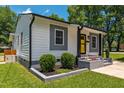 Charming home featuring a bright yellow door, gray accents, and professional landscaping for great curb appeal at 301 Williamson St, Burlington, NC 27215