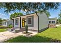 Charming home featuring a bright yellow door, gray accents, and professional landscaping at 301 Williamson St, Burlington, NC 27215
