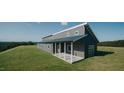 Beautiful modern home with gray siding, black trim, and a spacious covered porch nestled on a grassy hilltop at 345 Wake County Line Rd, Zebulon, NC 27597