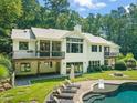 Expansive backyard featuring a luxurious pool, lounge seating, and a charming patio with ample space for outdoor enjoyment at 3707 Stonegate Dr, Chapel Hill, NC 27516