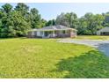 Beautiful ranch with a large front yard and gravel driveway to a detached garage at 4414 Nc Hwy 87 N, Pittsboro, NC 27312