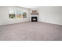 Cozy living room features a fireplace and large windows allowing for ample natural light and neutral carpet at 6228 Saybrooke Dr, Raleigh, NC 27604